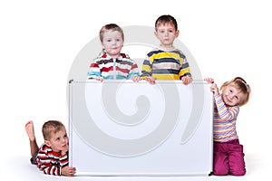 Four children holding a white board