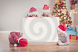 Four children indoors with empty banner on Christmas holiday.