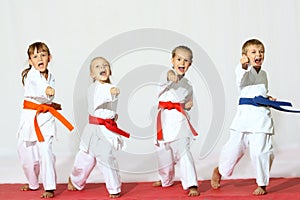 Four children in kimono hit a punch on a white background
