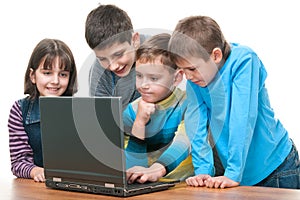 Four children studying using a laptop