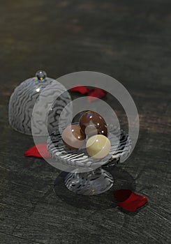 Four Chocolate balls on a glass cake stand.