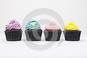 Four Chocolate Cup Cakes With Colorful Icing