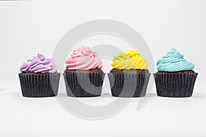 Four Chocolate Cup Cakes With Colorful Icing or Frosting