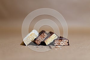 Four chocolate protein bars with different flavors in the context of sprinkle rice flakes on baking paper, Teflon paper. Whey prot