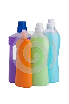 Four cleaning bottles with multi-colored liquids on white background