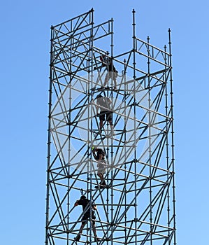 Four climbers riggers on a high metal structure