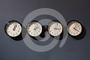 Four clocks on the black wall