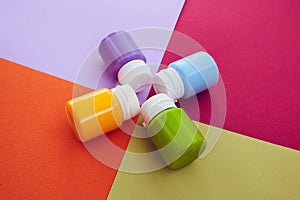 Four closed cans of acrylic paints on bright symmetry background. Place for text