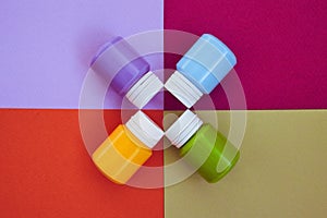 Four closed cans of acrylic paints on bright symmetry background. Place for text