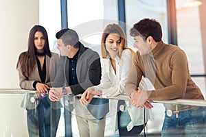 Four colleagues talking in the hall office building