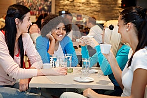 Four college chatting in a coffee shop photo