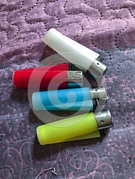 Four colored lighters, blue,red,yellow and white on a cloth