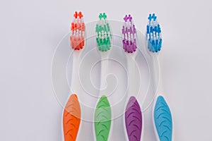 Four colored toothbrushes on white background.