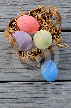 Four colorful Easter eggs and a pretty little basket