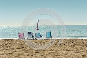 Colorful hammocks and closed umbrella in empty sandy beach