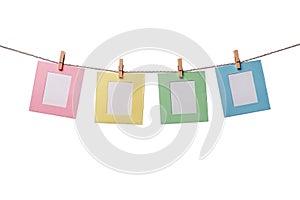 Four colorful paper photo frames hanging on the rope isolated on white