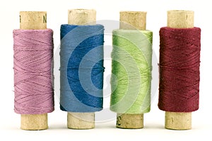 Four colorful thread spools