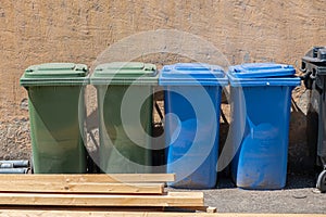 Four coloured dustbins in a row