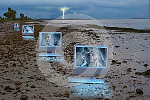 Four computers on a dark stormy beach