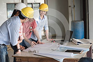 Four construction engineer working on blue print in side building plan for renovation, construction engineering conceptual