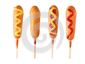 Four corn dogs with different toppings isolated on white