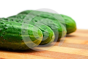 Four cucumbers with pimples on kitchen board