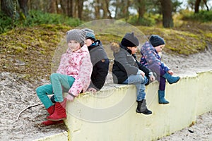 Four cute little children having fun together on beautiful spring day. Funny kids hanging together outdoors