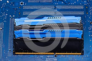 Four DDR memory chips in different colors lying on a blue printed circuit board.