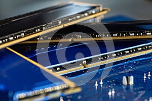 Four DDR memory chips in different colors lying on a blue printed circuit board.