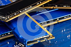 Four DDR memory chips in different colors lying on a blue printed circuit board.