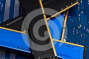 Four DDR memory chips in different colors lying on a blue printed circuit board.