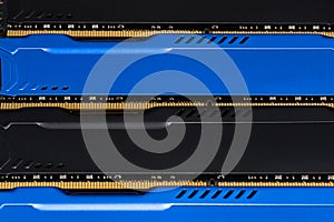 Four DDR memory chips in different colors lying on a blue printed circuit board.