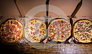 Four different delicious pizzas in boxes