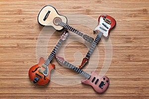 Four different electric and acoustic guitars on a wooden background. Toy guitars. Music concept.