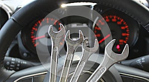 Four Different Size Chrome Spanners In Front Of Defocused Instrument Cluster With Red Backlight