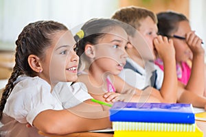 Four diligent pupils studying at classroom