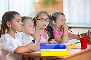 Four diligent pupils studying at classroom photo