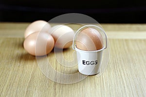 Four eggs in egg cups on a wooden table black background