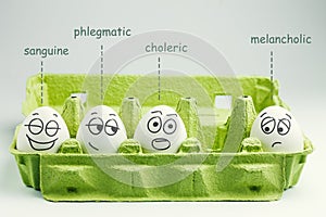 Four eggs in eggbox. Types of temperaments. Sanguine, choleric, phlegmatic and melancholic photo