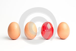 Four eggs in a row with one red one