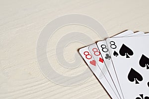 four eight poker hands playing cards on a light desk background.