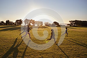 Four elementary school children running in an open field