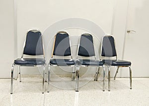 Four empty navy blue chairs in front of the room for waiting purpose