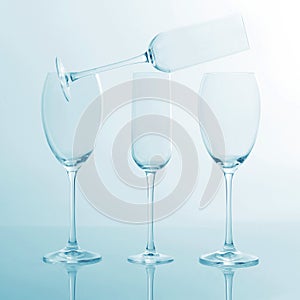 Four empty wine glass on a light blue background