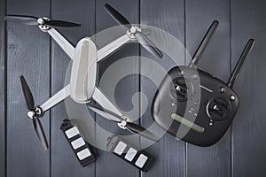 Four-engine drone with two spare batteries and dual frequency radio control on gray wooden background