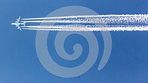Four engined airplane during flight in high altitude with condensation trails