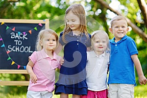 Four excited little kids by a chalkboard