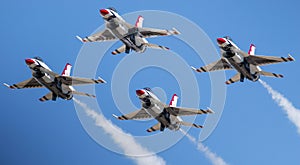 Four F-16 usaf Thunderbirds flying in the diamond formation with a blue sky