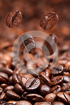 Four falling beans and dark roasted coffee