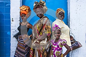 Four female celebrants of Emancipation Day pose against a wall on Picadilly Street, Port-of-Spain, Trinidad on Emancipation Day